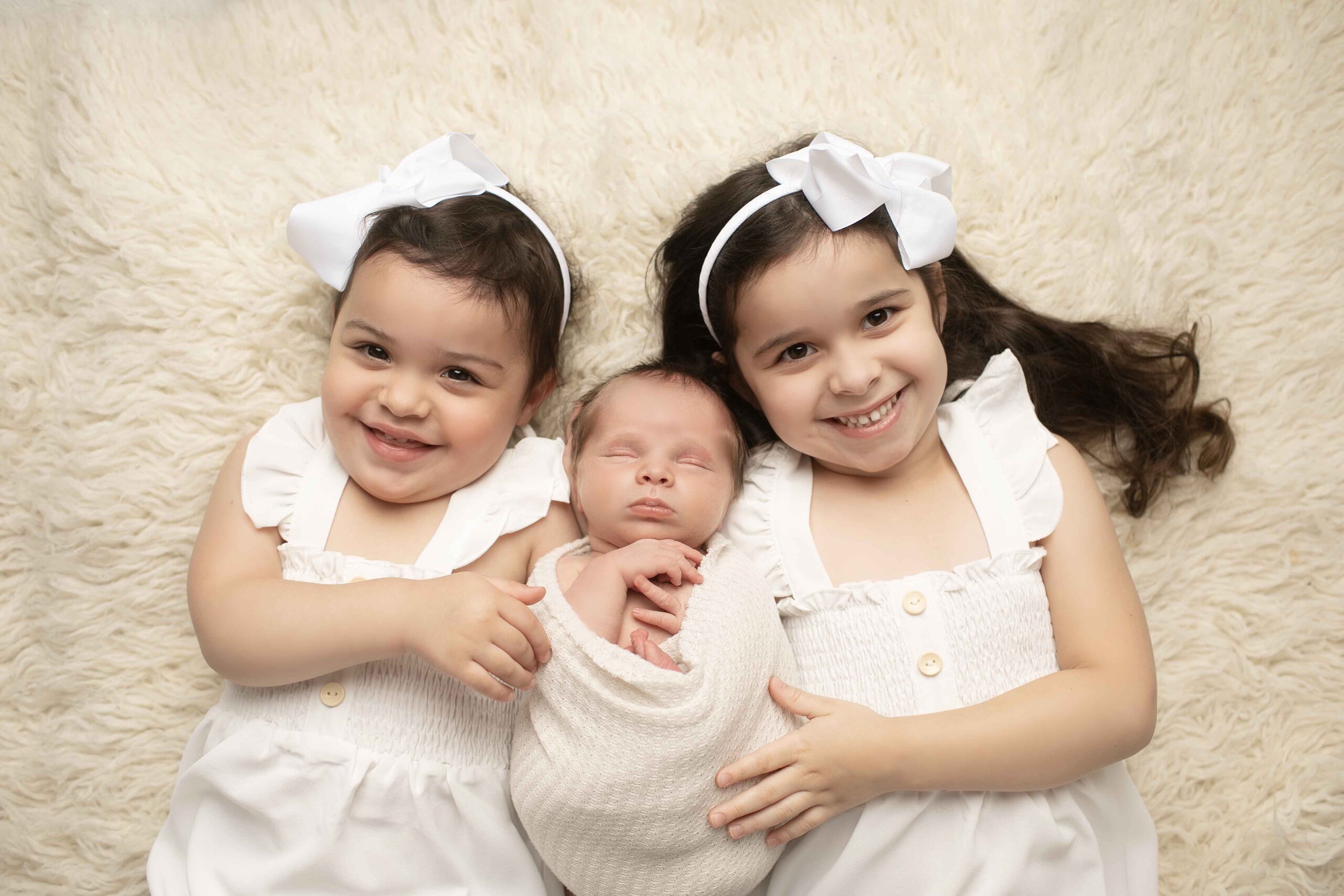 Siblings smiling with newborn brother | Chunky Monkey Photography