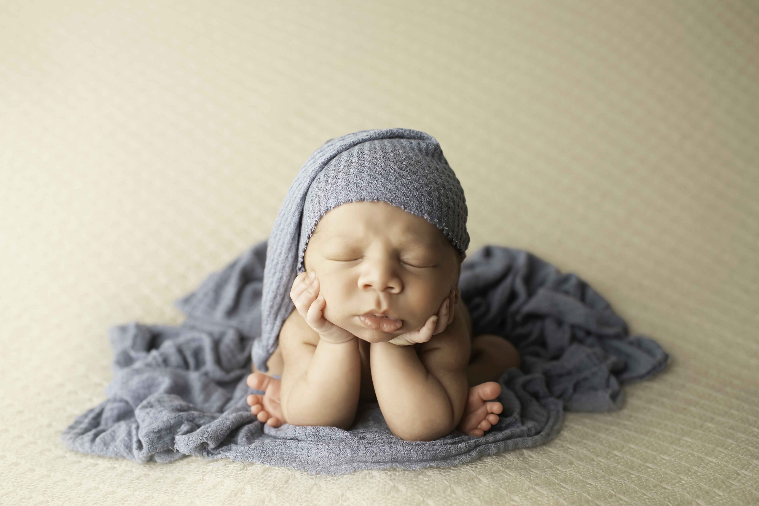 Newborn Baby Boy with Blue Hat in Froggy position