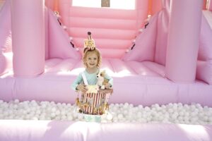 Little girl turning 5 in a pink jump house 