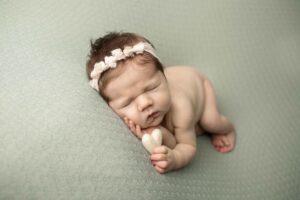 Newborn Baby Girl holding a heart 