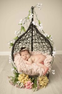Newborn Baby Girl in a hanging basket with flowers 