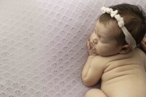 Newborn Baby Girl on a Purple Backdrop