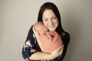 Newborn Baby Girl in pink wrap with Mom