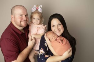 Newborn Baby Girl in pink wrap with Mom and Dad and big sister