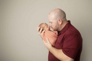 Newborn Baby Girl in pink wrap with Dad