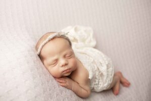Newborn Baby Girl on Purple Blanket side laying