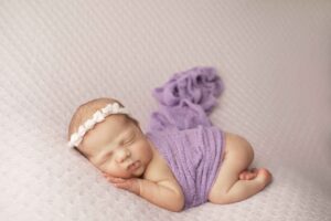 Newborn Baby Girl on Purple Blanket with purple wrap