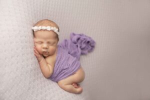 Newborn Baby Girl on Purple Blanket with purple wrap