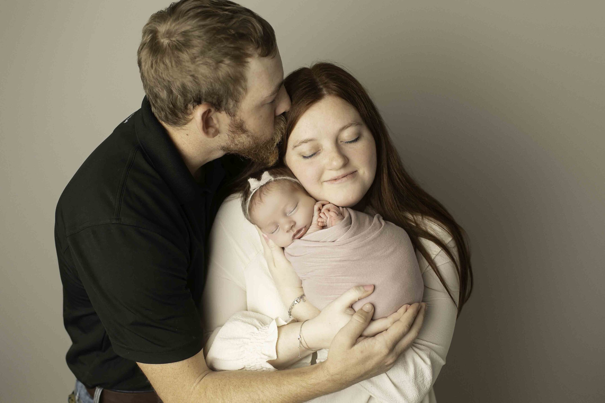 Newborn baby girl with mom and dad posed