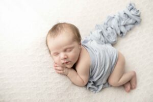 Newborn Baby Boy on white blanket with blue wrap