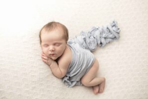 Newborn Baby Boy on white blanket with blue wrap