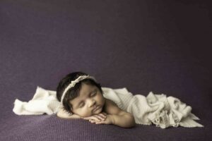 Newborn Baby Girl on purple with white wrap 