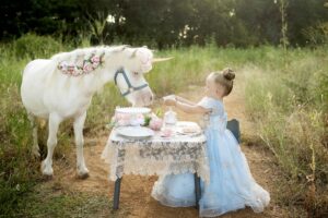 Child as a princess with a tea party with a unicorn
