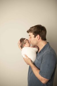 Newborn Baby Girl with dad kissing her nose 