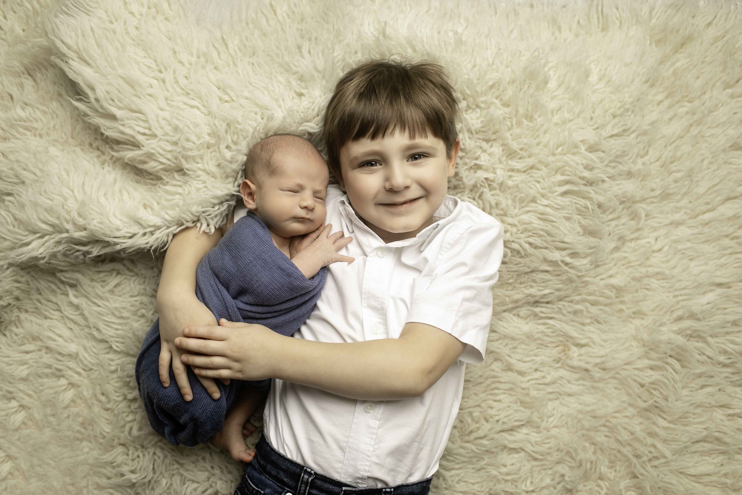 Newborn Baby Boy with Big Brother laying down