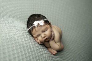 Newborn Baby Girl posed with hands on face