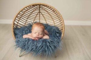 Newborn Baby Boy with Red Hair in boho basket
