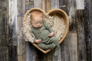 Newborn Baby Boy in green footie in heart bowl