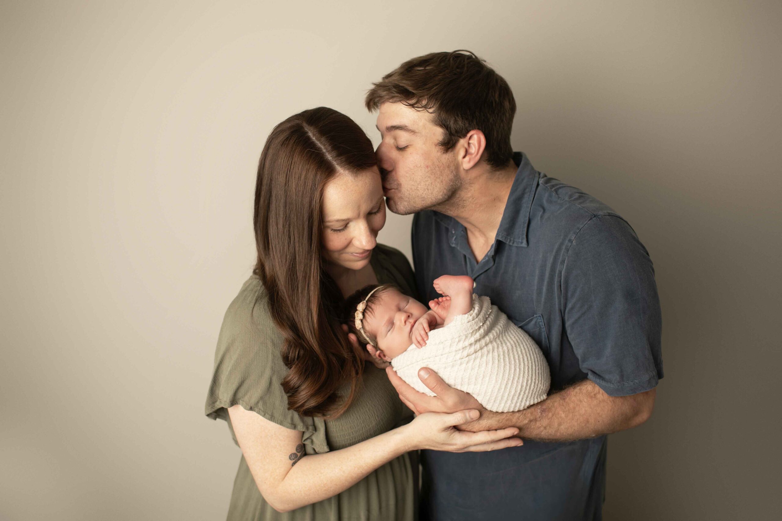 Newborn Baby Girl with mom and dad kissing mom