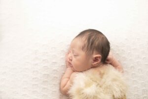 Newborn Baby Girl on White Blanket with angel wings