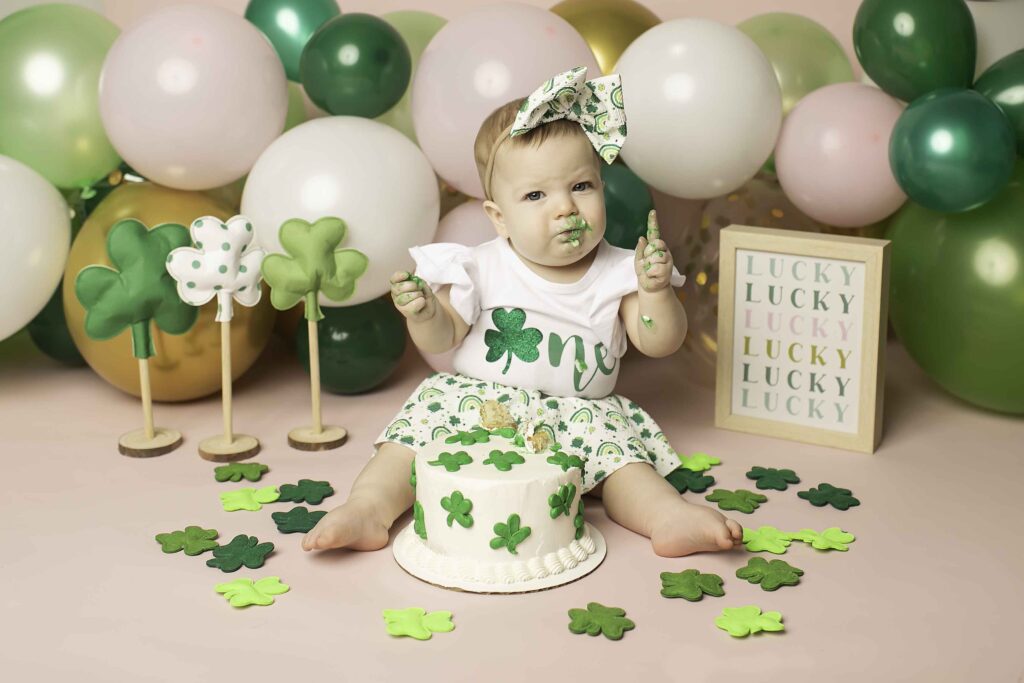 Captured in a whimsical Lucky Clover setting, the birthday girl smashes her cake with excitement at Chunky Monkey Photography Studio in Azle, TX