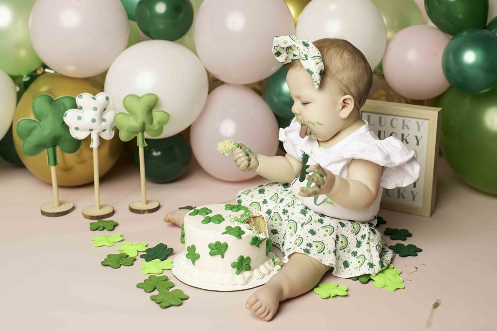 Captured at Chunky Monkey Photography Studio in Azle, TX, a birthday girl in a green dress celebrates her first birthday with a Lucky Clover theme, surrounded by cheerful decor.