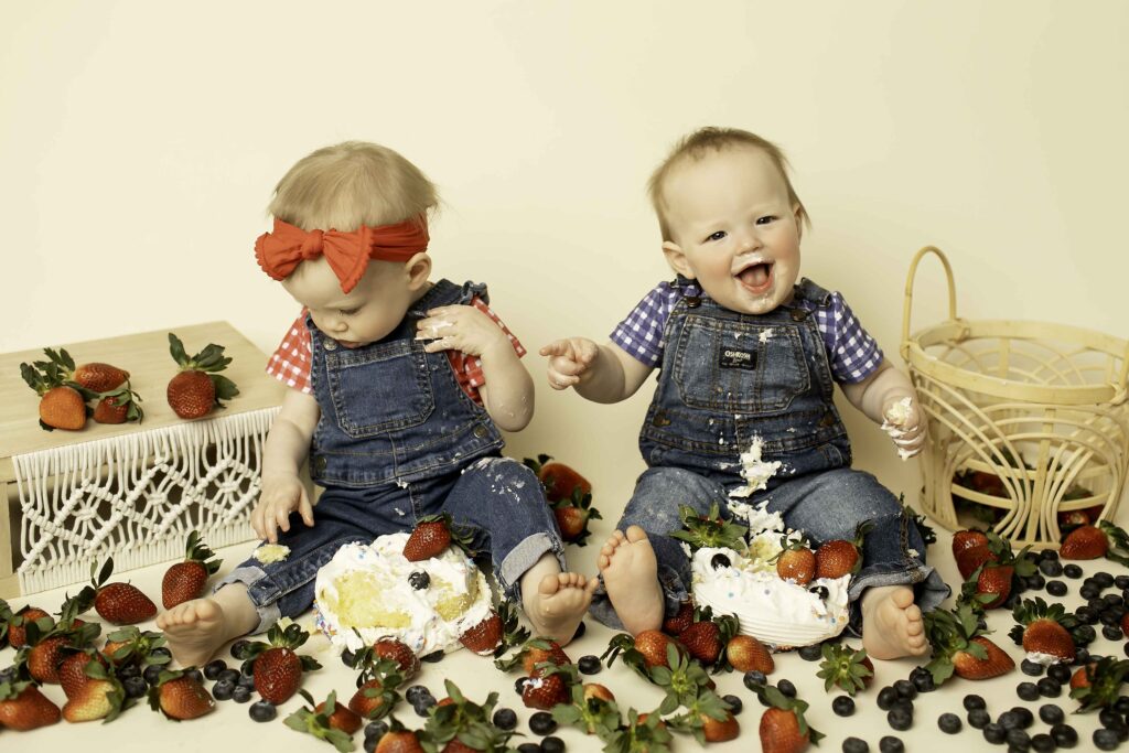 Strawberry-themed birthday fun for twins, as Chunky Monkey Photography beautifully captures the messy and joyful moments of the smash cake