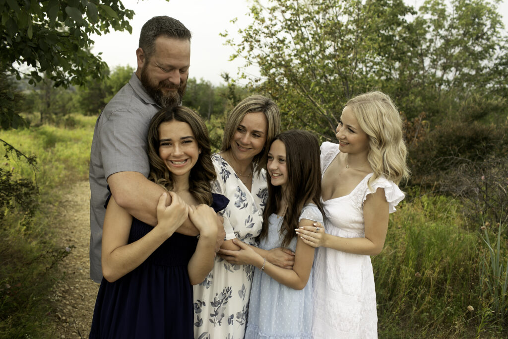 The sun sets behind a family of five at Tandy Hills, capturing the bittersweet moments with the three sisters as the eldest prepares to go to college