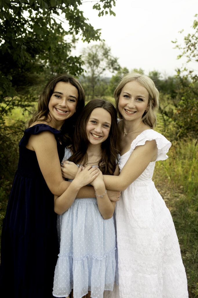 A beautiful, candid portrait of three sisters at Tandy Hills, Fort Worth, as they embrace the moment before the oldest leaves for college