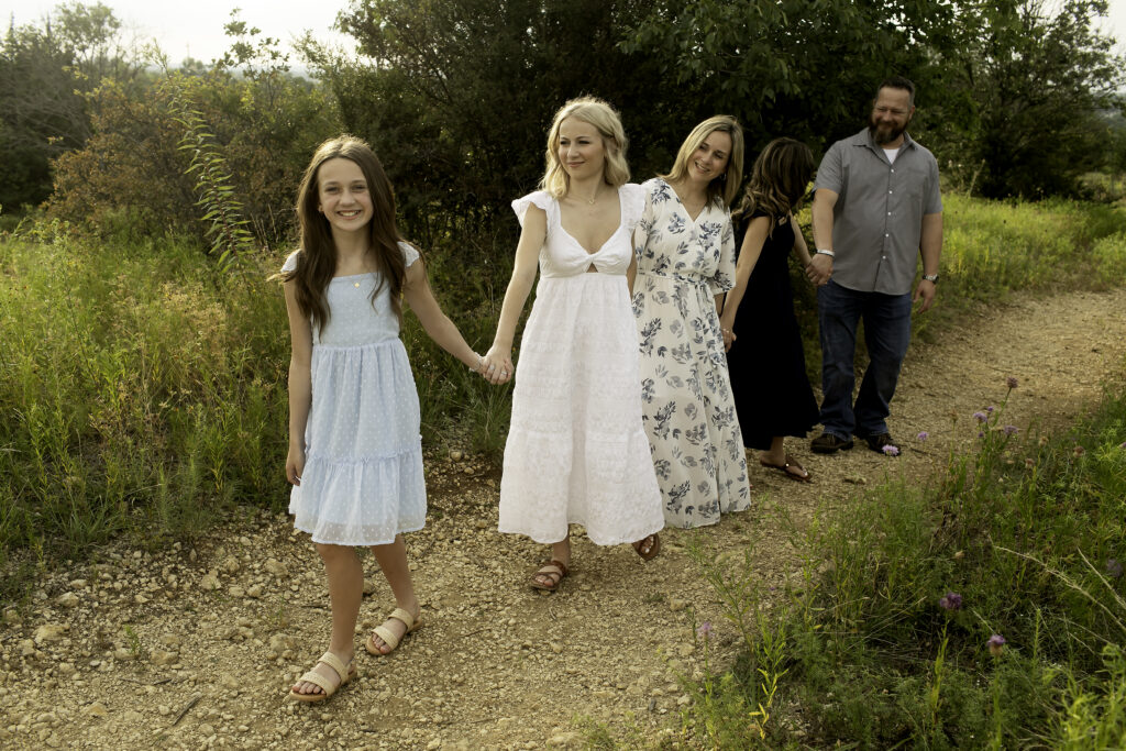 The family of five embraces at Tandy Hills, Fort Worth, where three sisters create lasting memories, marking the special time before the oldest begins her college journey