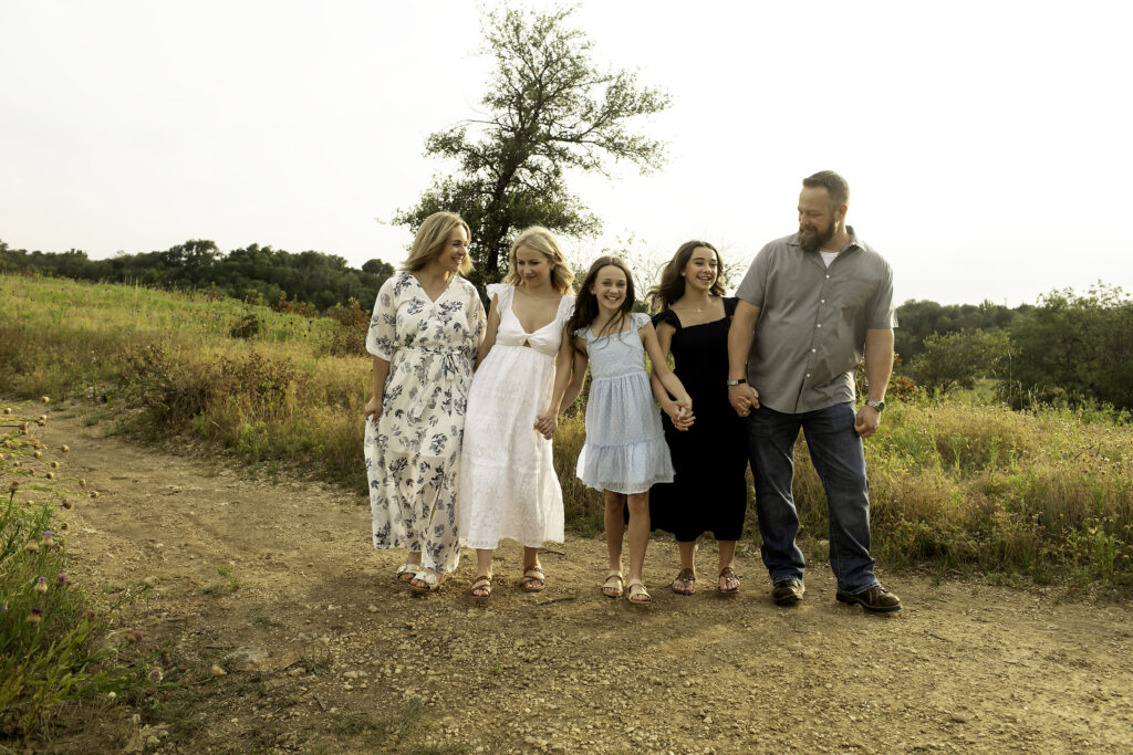 A playful family portrait at Tandy Hills, Fort Worth, where the three sisters and their parents make memories before the oldest departs for college