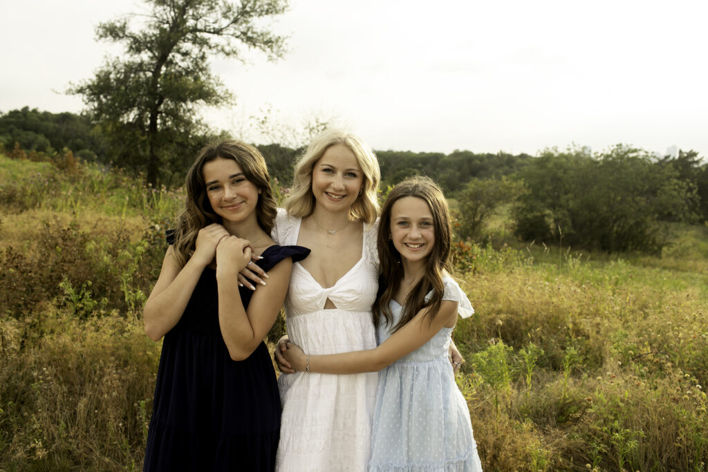 A heartfelt moment between three sisters at Tandy Hills, Fort Worth, cherishing their time together in the peaceful surroundings before the oldest sister heads off to college.