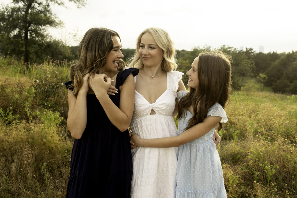 The three sisters standing together on the hills of Fort Worth, with the oldest sister preparing for the next chapter in her college journey