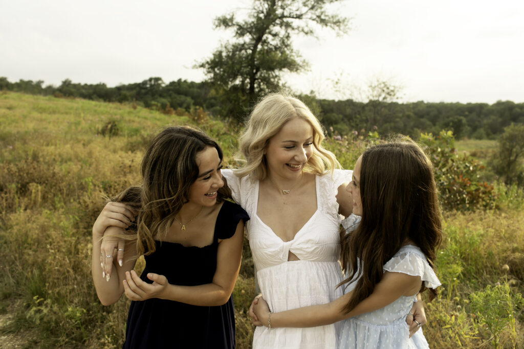 A playful moment between three sisters at Tandy Hills, capturing their closeness as they enjoy the stunning landscape