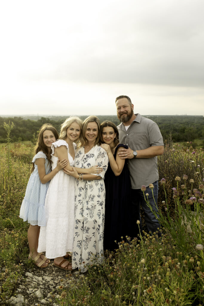 A warm, golden hour photoshoot at Tandy Hills with a family of five, the three sisters embracing their bond as the oldest sister prepares for college