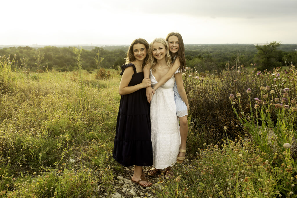 Three sisters laughing together at Tandy Hills, Fort Worth, embracing the beauty of nature and their special bond