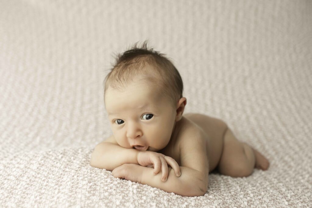 A calm and serene moment with a newborn posed simply on a fluffy blanket, radiating innocence and tranquility, captured by Chunky Monkey Photography