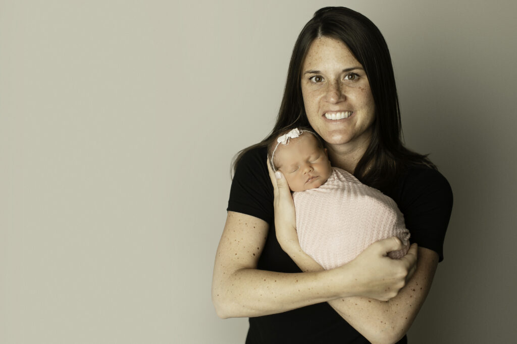 Mom and her newborn daughter share a tender embrace, capturing the sweet connection between them in this beautiful shot by Chunky Monkey Photography