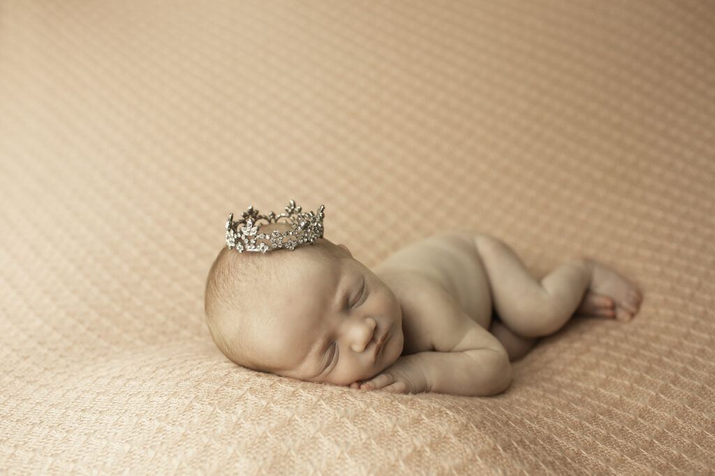 A newborn girl peacefully posed on a pink blanket, captured in a pure, simple moment by Chunky Monkey Photography