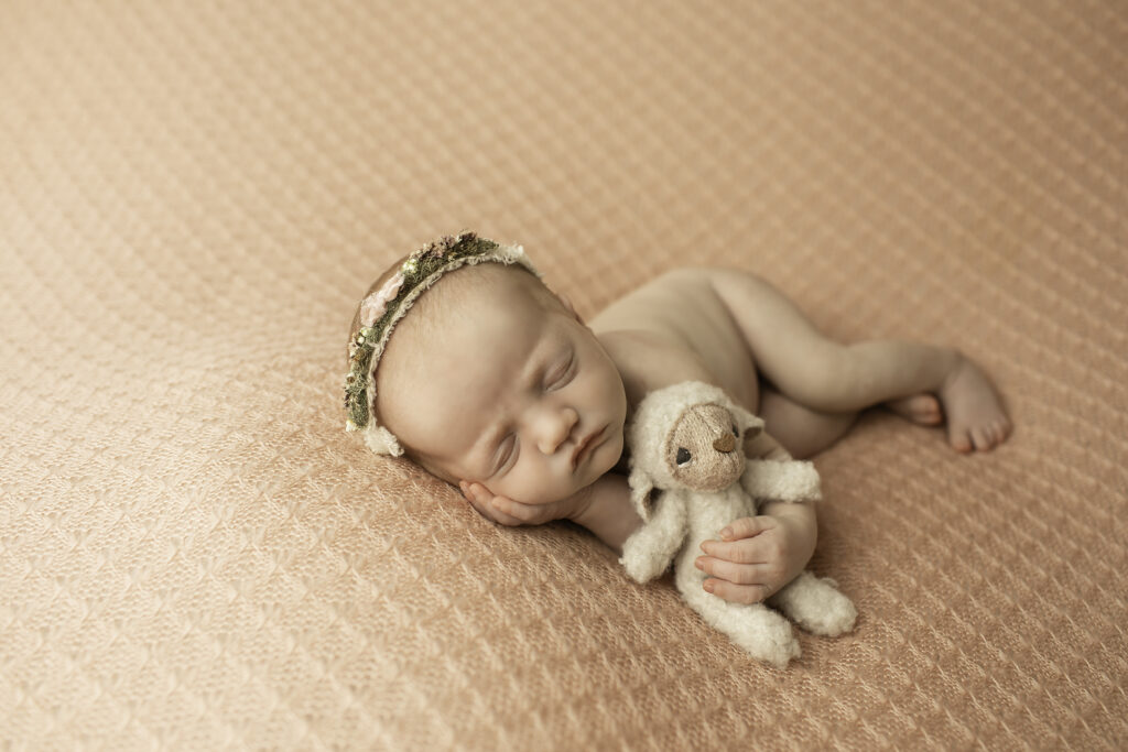 Chunky Monkey Photography captures the beauty of a newborn girl, resting effortlessly on a soft pink blanket in a gentle and minimalist pose