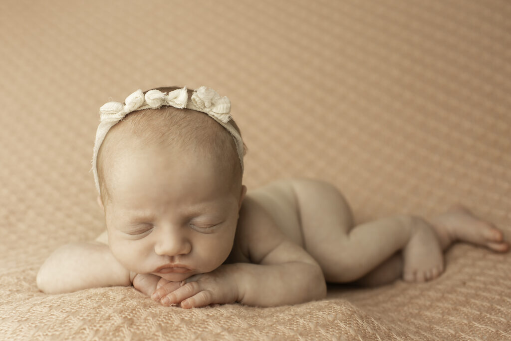 Simple and sweet, a newborn girl resting gently on a pink blanket, radiating innocence and calm in this beautiful shot by Chunky Monkey Photography.