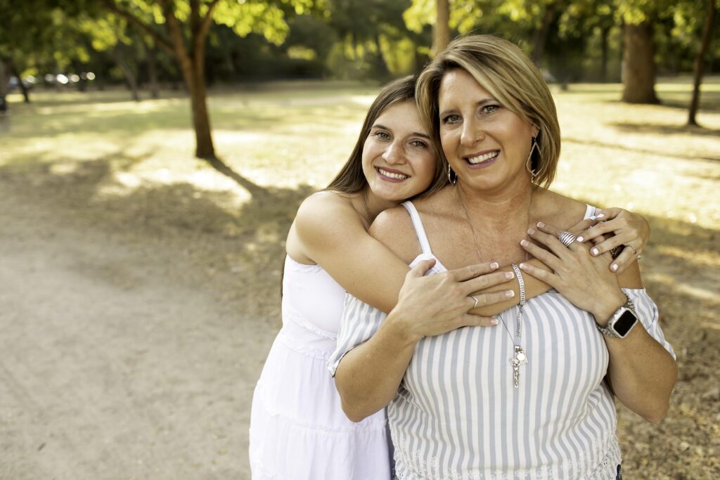 Senior girl and her mom sharing a sweet moment on a dirt road at Trinity Park