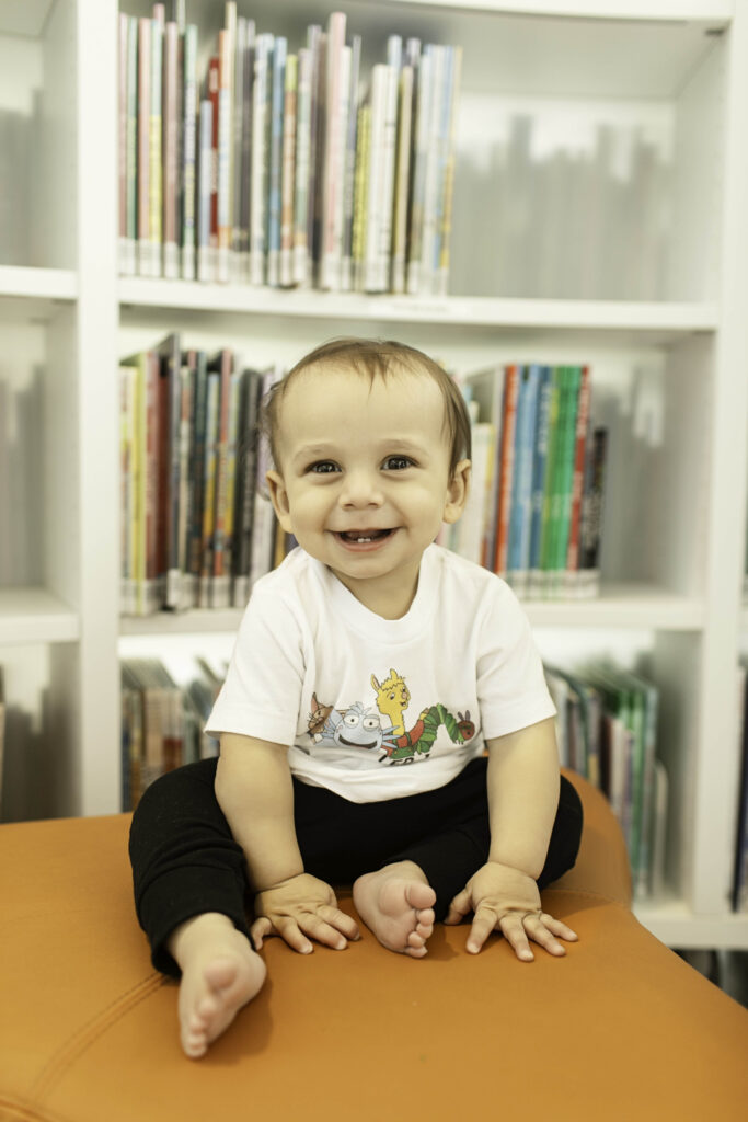 In the heart of the Library in Fort Worth, TX, a 1-year-old smiles and giggles, creating precious memories during their first birthday photoshoot in this inspiring space