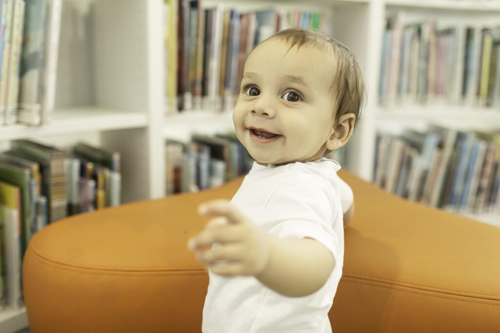 A little one beams with excitement during their 1st birthday photoshoot at the Library in Fort Worth, TX, creating lasting memories in a place full of stories and adventure