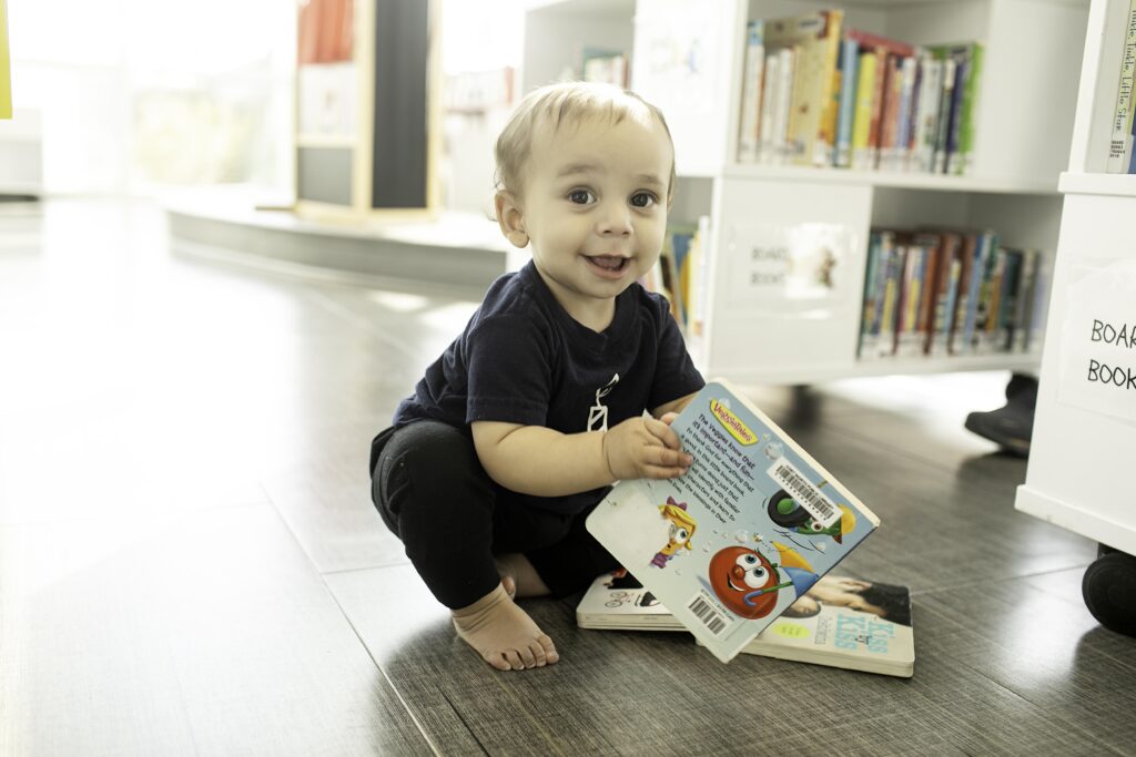 In the heart of the Library in Fort Worth, TX, a 1-year-old celebrates their birthday with a playful photoshoot, surrounded by the love of family and the wisdom of books