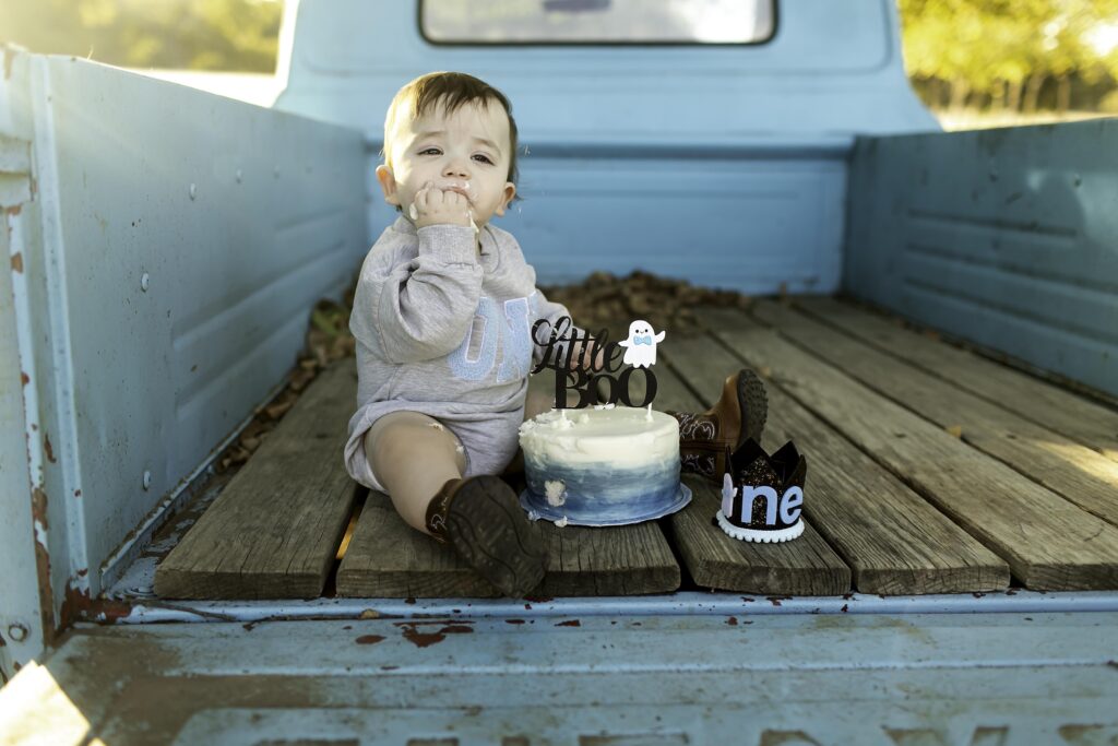 Birthday boy savoring his cake in the bed of a vintage truck, making a sweet memory.