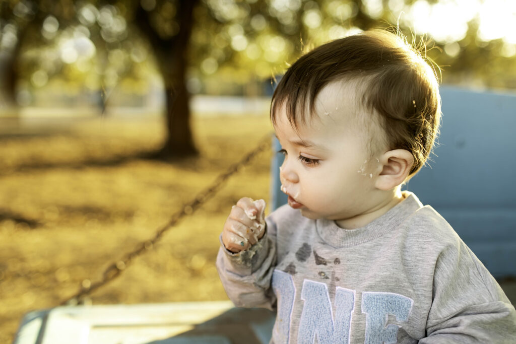 Birthday boy happily eating cake in the bed of an old truck, surrounded by a fun, rustic setting