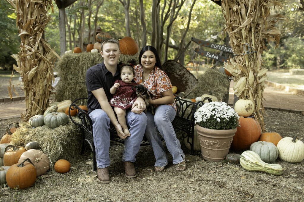 Captured at Clark Gardens in Mineral Wells, TX, a mom and dad share a joyful moment with their 1-year-old, marking their baby’s first birthday with love and laughter.