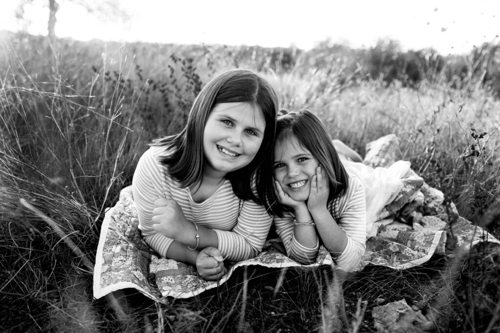 sisters playing and exploring in a park, enjoying outdoor fun together