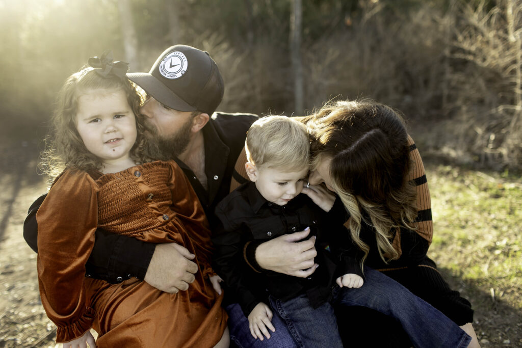 A happy family of four enjoying quality time together outdoors, smiling and laughing